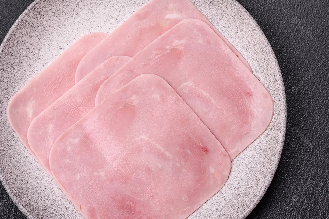 A imagem mostra fatias de presunto, que é um produto de charcutaria feito de carne de porco.