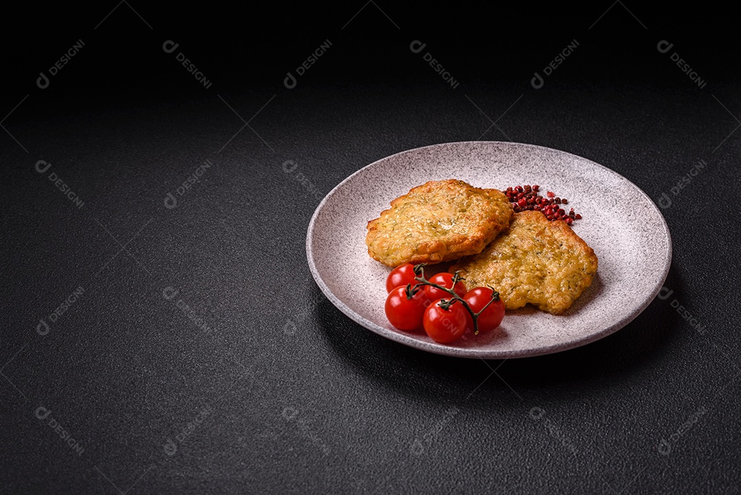 A imagem mostra pedaços de frango frito, acompanhados por tomates cereja e pimenta rosa.