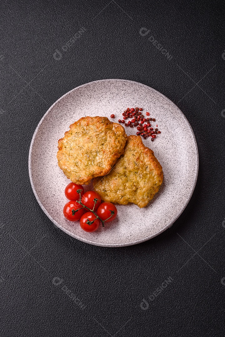 A imagem mostra pedaços de frango frito, acompanhados por tomates cereja e pimenta rosa.
