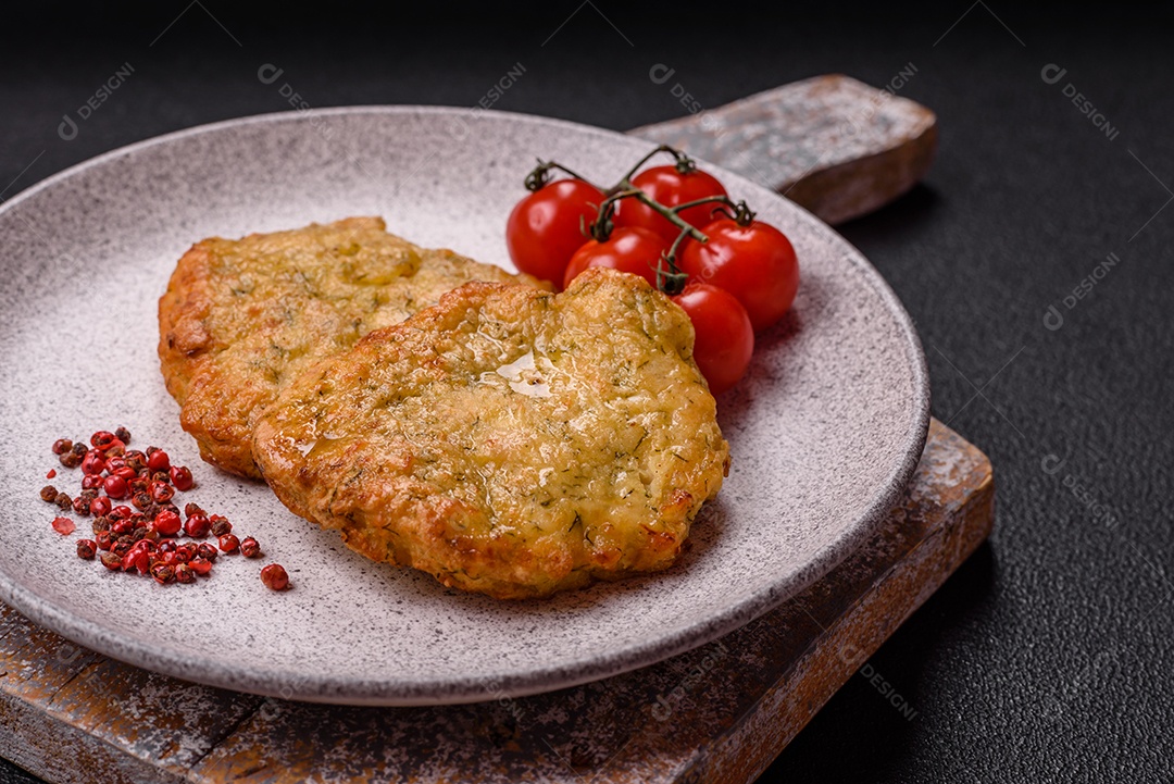 A imagem mostra pedaços de frango frito, acompanhados por tomates cereja e pimenta rosa.