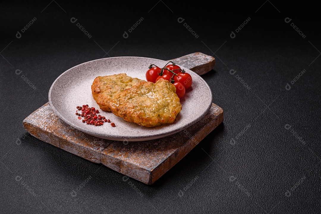 A imagem mostra pedaços de frango frito, acompanhados por tomates cereja e pimenta rosa.