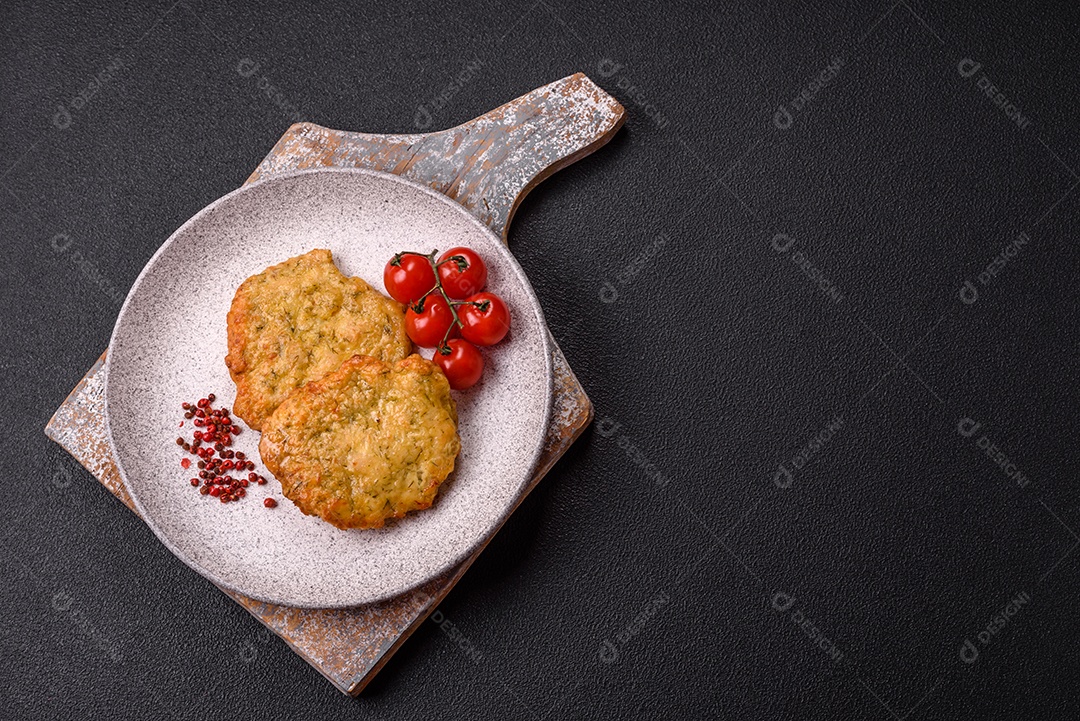 A imagem mostra pedaços de frango frito, acompanhados por tomates cereja e pimenta rosa.