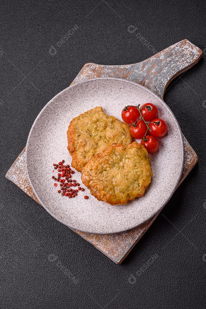 A imagem mostra pedaços de frango frito, acompanhados por tomates cereja e pimenta rosa.