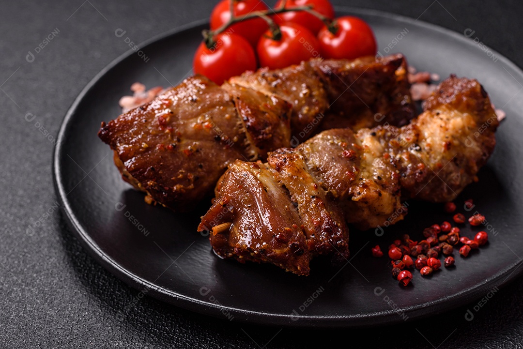 A imagem mostra costelinha de porco assada, servida em um prato escuro