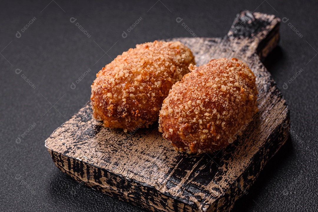 A imagem mostra Frango à Kiev, um prato de frango empanado e frito, recheado com manteiga de ervas.