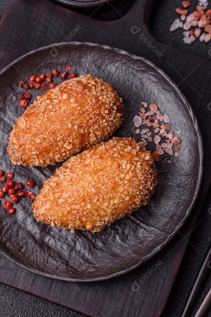 A imagem mostra Frango à Kiev, um prato de frango empanado e frito, recheado com manteiga de ervas.