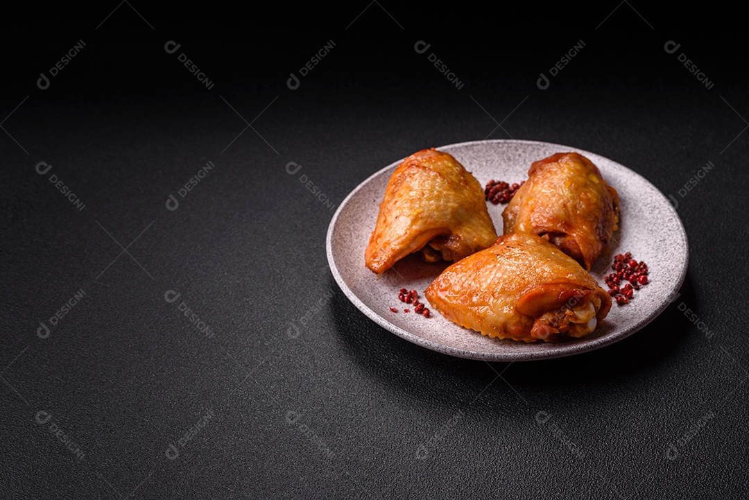 A imagem mostra sobrecoxas de frango ou coxas de frango em um prato escuro