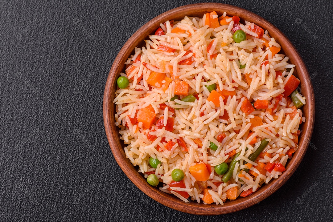 A imagem mostra um prato de arroz cozido com vegetais, como cenoura e vagem