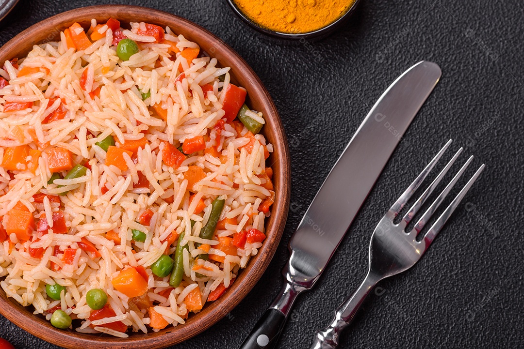 A imagem mostra um prato de arroz cozido com vegetais, como cenoura e vagem