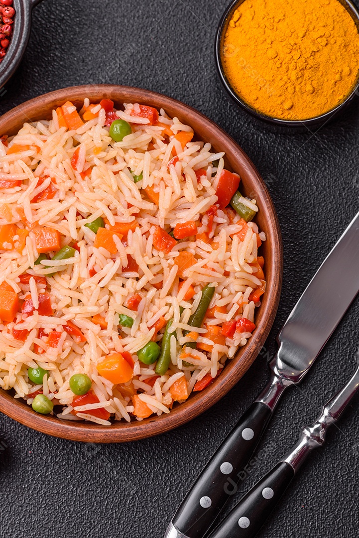 A imagem mostra um prato de arroz cozido com vegetais, como cenoura e vagem