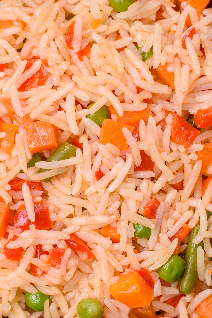 A imagem mostra um prato de arroz cozido com vegetais, como cenoura e vagem