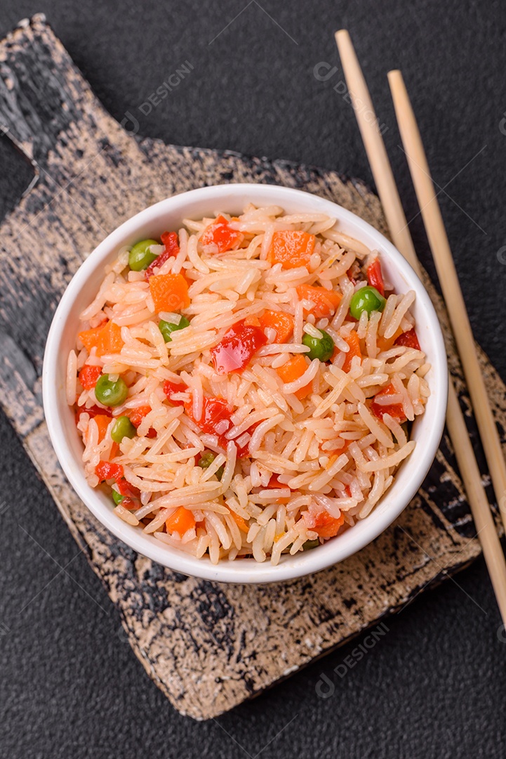 A imagem mostra um prato de arroz com vegetais, servido em uma tigela branca com um par de hashis