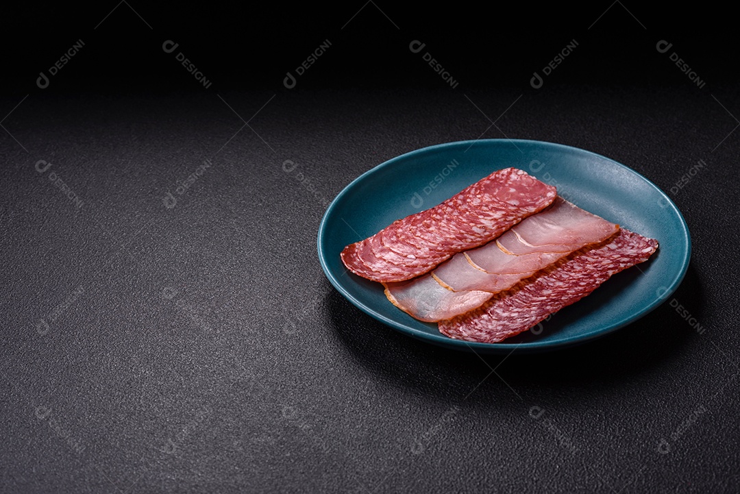 A imagem mostra uma tábua com fatias de salame e presunto, acompanhadas de temperos e especiarias como pimenta-do-reino e páprica.