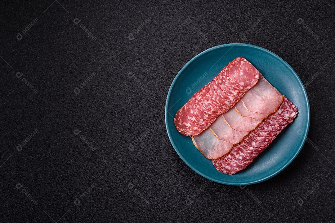 A imagem mostra uma tábua com fatias de salame e presunto, acompanhadas de temperos e especiarias como pimenta-do-reino e páprica.