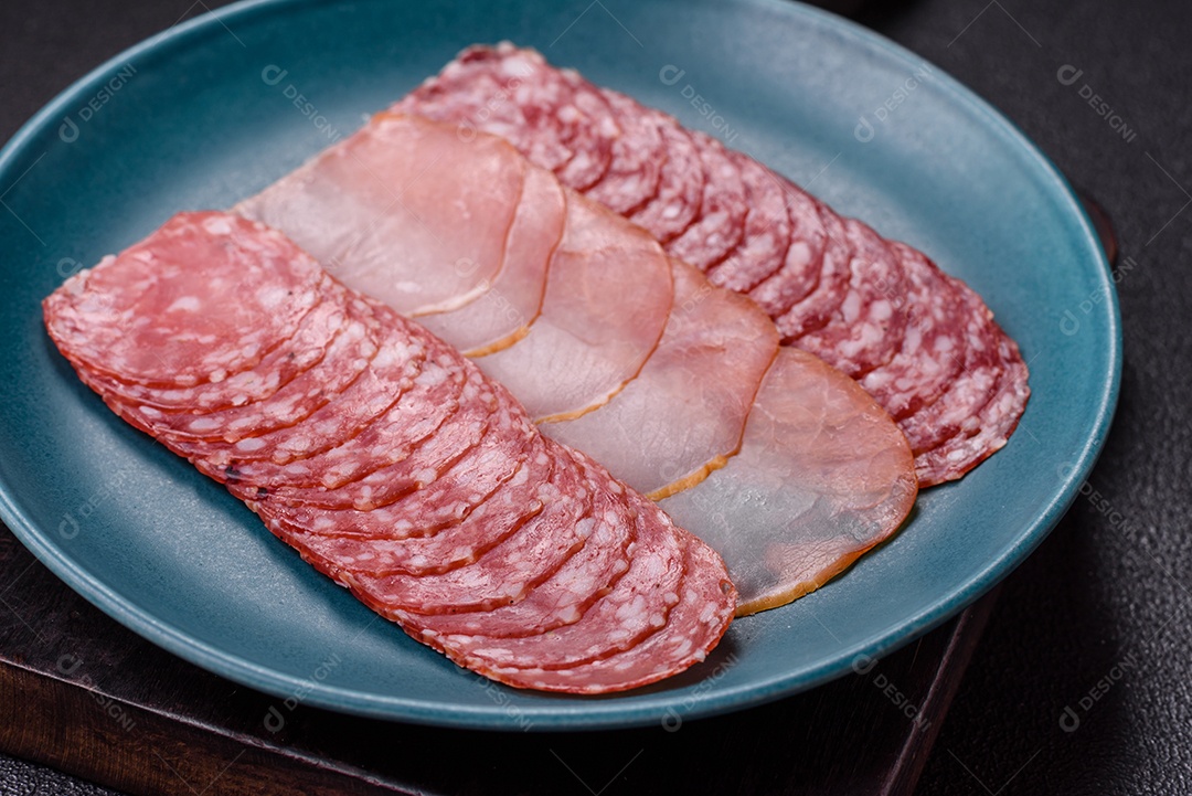 A imagem mostra uma tábua com fatias de salame e presunto, acompanhadas de temperos e especiarias como pimenta-do-reino e páprica.