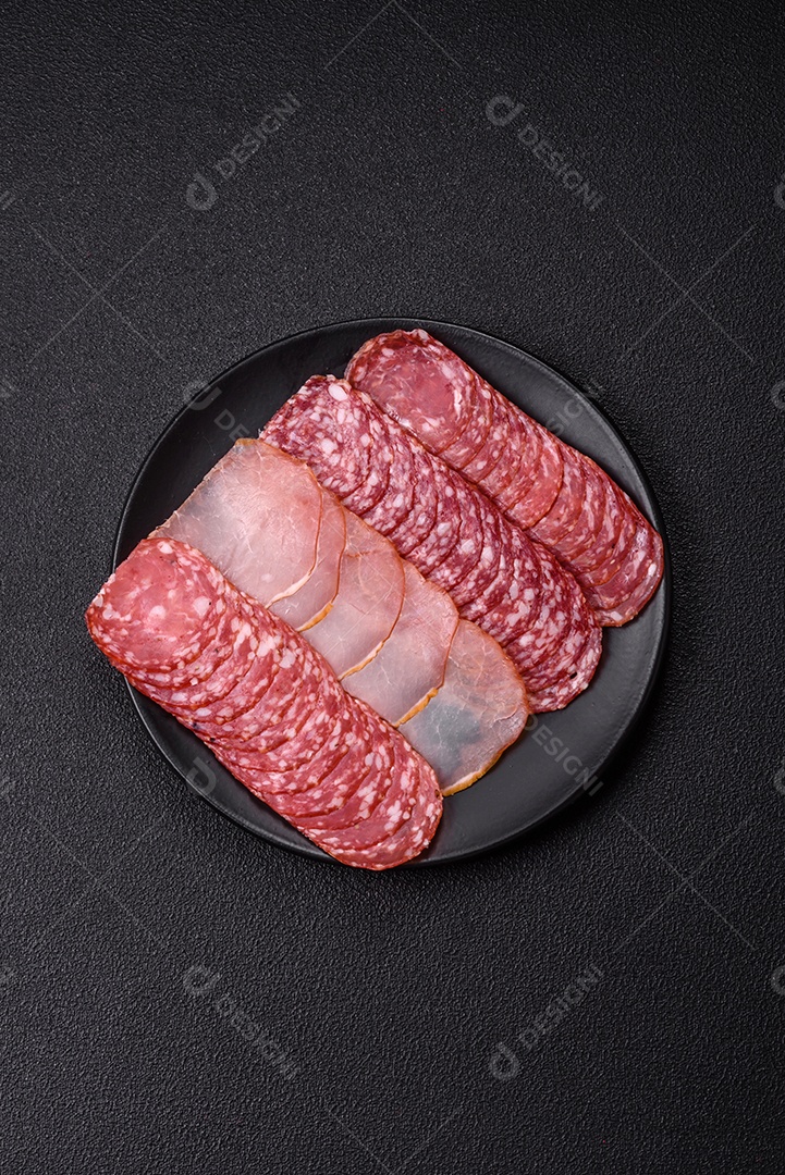 A imagem mostra uma tábua com fatias de salame e presunto, acompanhadas de temperos e especiarias como pimenta-do-reino e páprica.