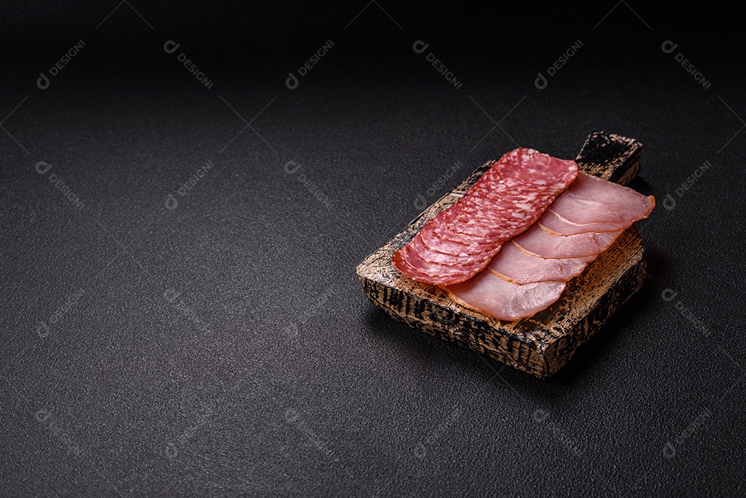 A imagem mostra uma tábua com fatias de salame e presunto, acompanhadas de temperos e especiarias como pimenta-do-reino e páprica.