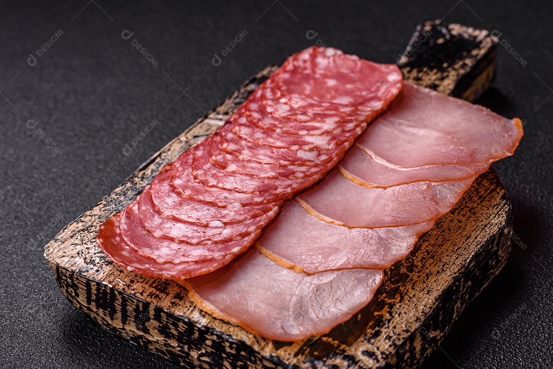 A imagem mostra uma tábua com fatias de salame e presunto, acompanhadas de temperos e especiarias como pimenta-do-reino e páprica.