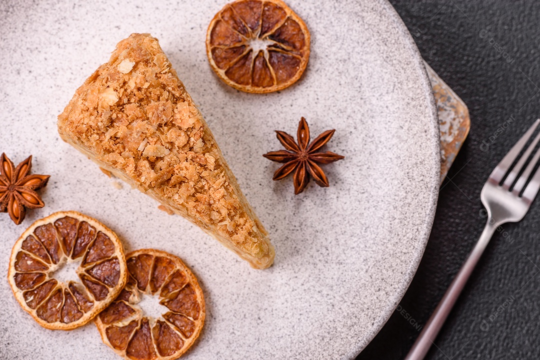 A imagem mostra um pedaço de Bolo Napoleão, uma sobremesa clássica que se assemelha ao mil-folhas.