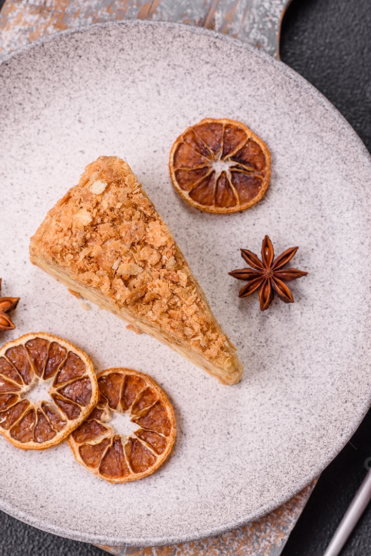 A imagem mostra um pedaço de Bolo Napoleão, uma sobremesa clássica que se assemelha ao mil-folhas.