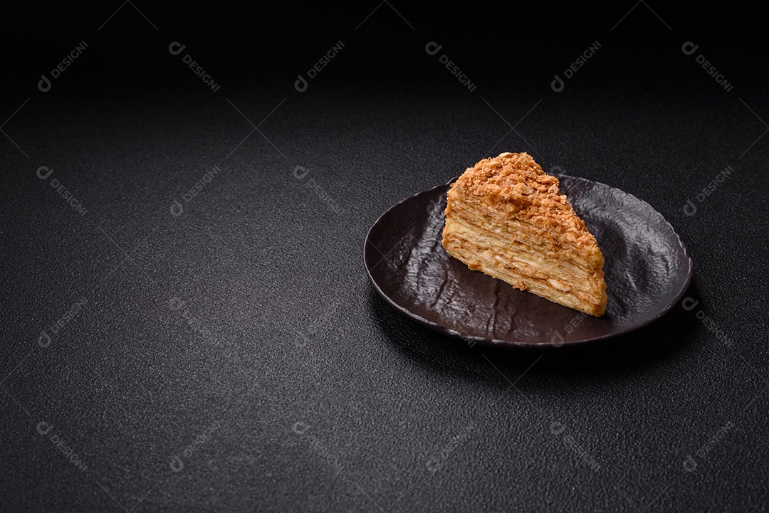 A imagem mostra um pedaço de Bolo Napoleão, uma sobremesa clássica que se assemelha ao mil-folhas.