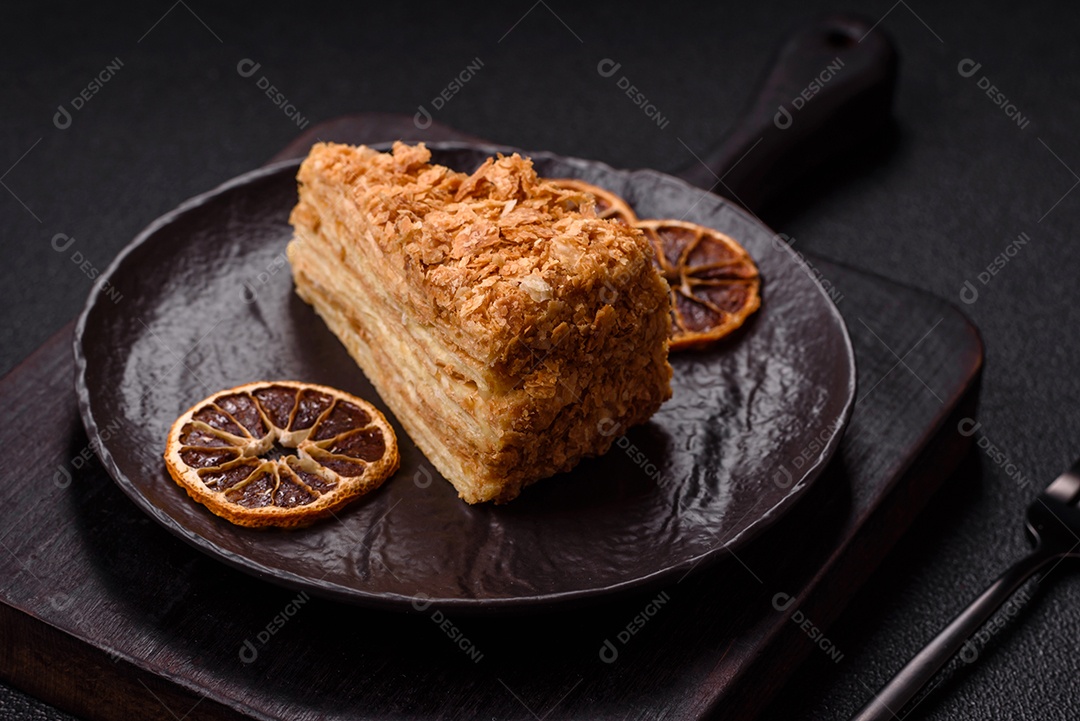 A imagem mostra um pedaço de Bolo Napoleão, uma sobremesa clássica que se assemelha ao mil-folhas.