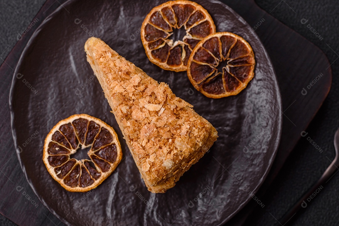 A imagem mostra um pedaço de Bolo Napoleão, uma sobremesa clássica que se assemelha ao mil-folhas.