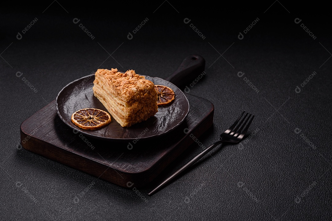 A imagem mostra um pedaço de Bolo Napoleão, uma sobremesa clássica que se assemelha ao mil-folhas.