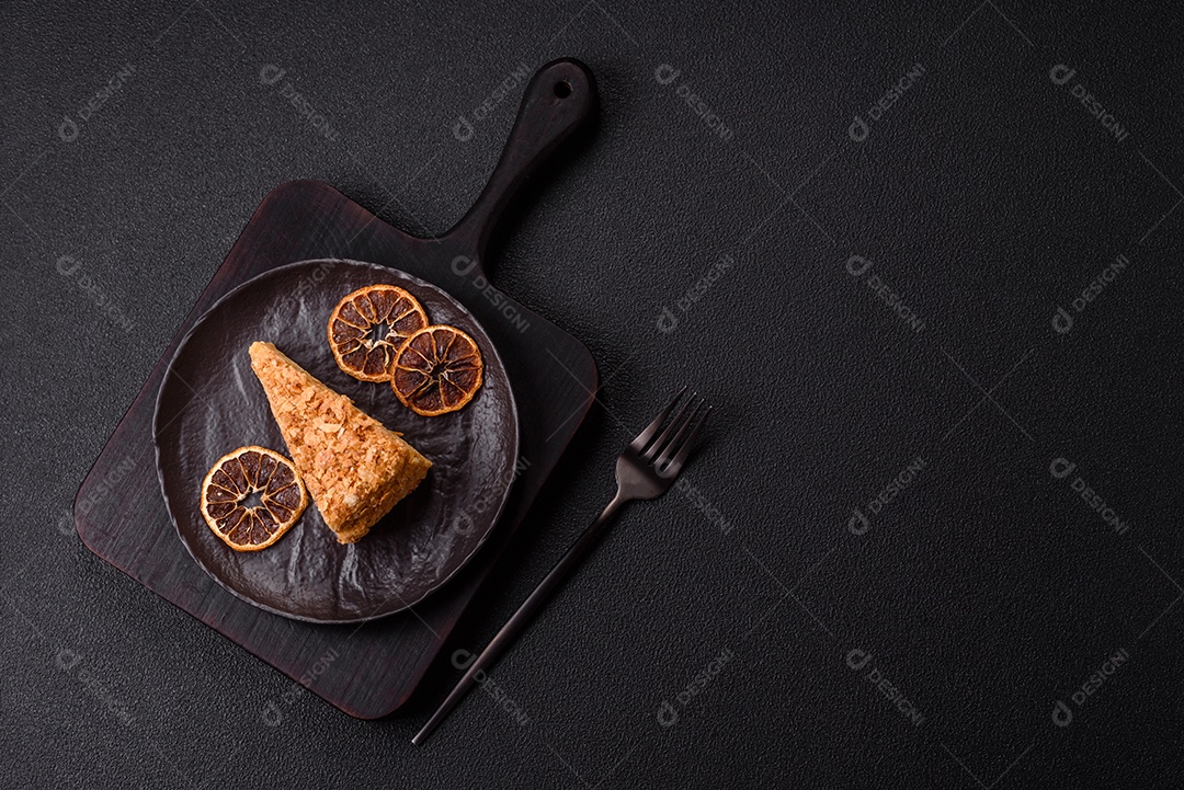 A imagem mostra um pedaço de Bolo Napoleão, uma sobremesa clássica que se assemelha ao mil-folhas.