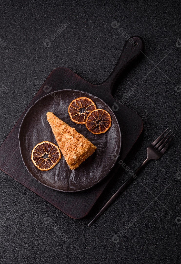 A imagem mostra um pedaço de Bolo Napoleão, uma sobremesa clássica que se assemelha ao mil-folhas.