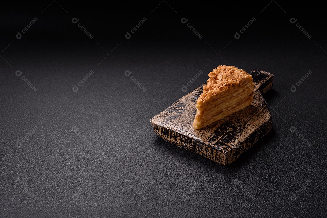 A imagem mostra um pedaço de Bolo Napoleão, uma sobremesa clássica que se assemelha ao mil-folhas.