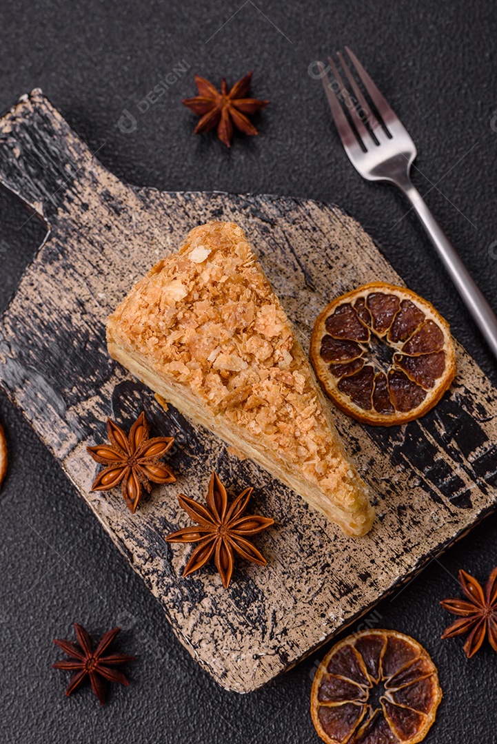 A imagem mostra um pedaço de Bolo Napoleão, uma sobremesa clássica que se assemelha ao mil-folhas.