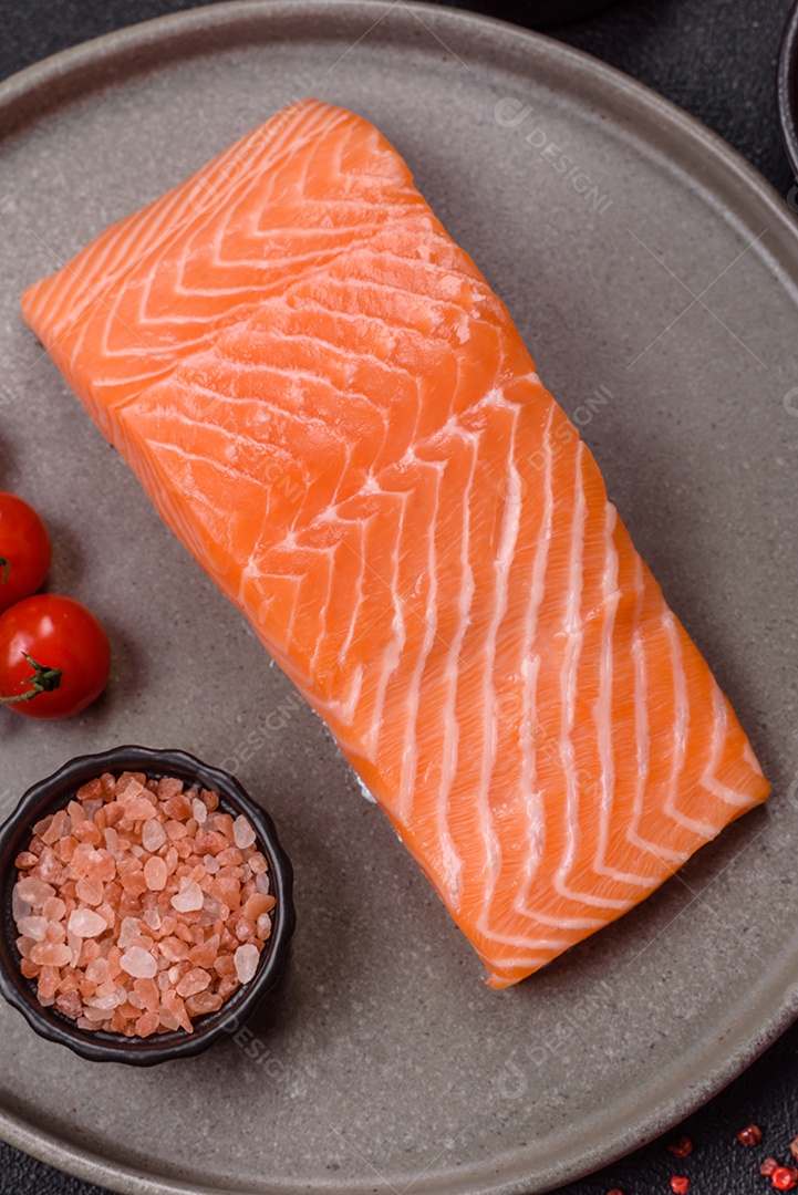 A imagem mostra um filé de salmão fresco em um prato escuro, acompanhado de temperos.