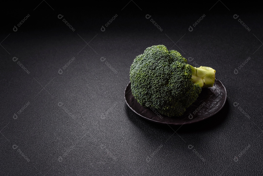 A imagem mostra um brócolis em uma tábua de corte de madeira.