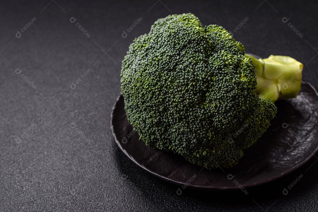 A imagem mostra um brócolis em uma tábua de corte de madeira.