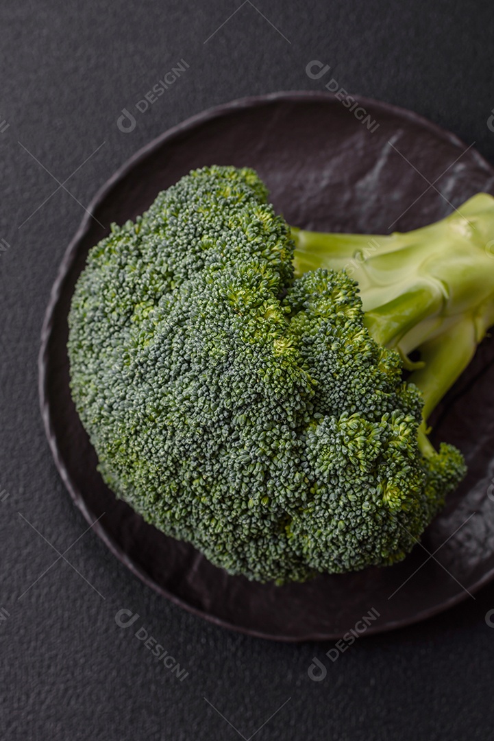 A imagem mostra um brócolis em uma tábua de corte de madeira.