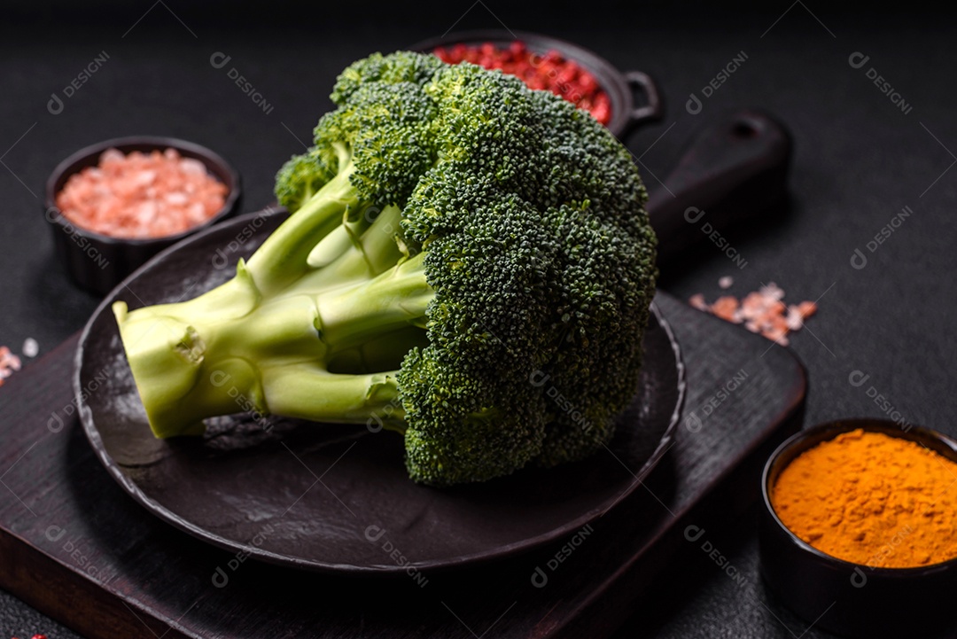 A imagem mostra um brócolis em uma tábua de corte de madeira.
