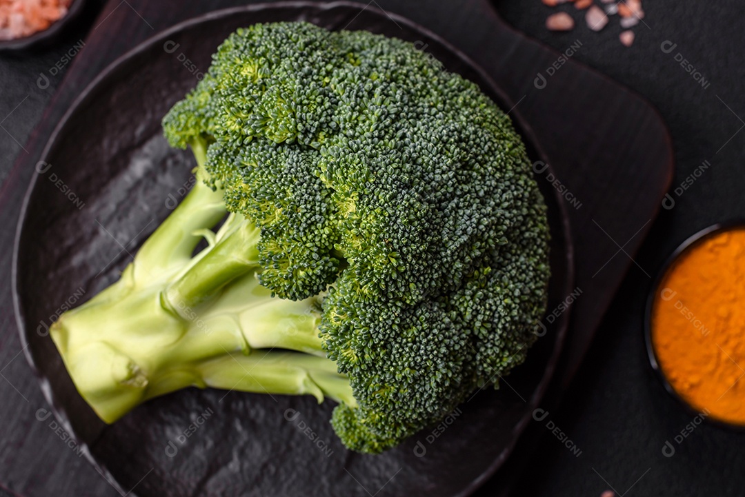 A imagem mostra um brócolis em uma tábua de corte de madeira.