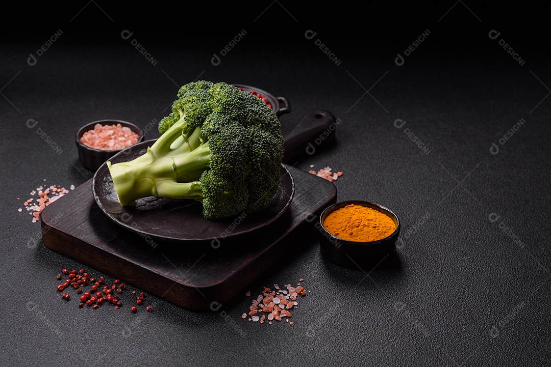 A imagem mostra um brócolis em uma tábua de corte de madeira.