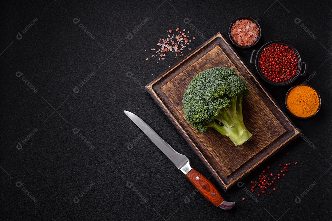 A imagem mostra um brócolis em uma tábua de corte de madeira.