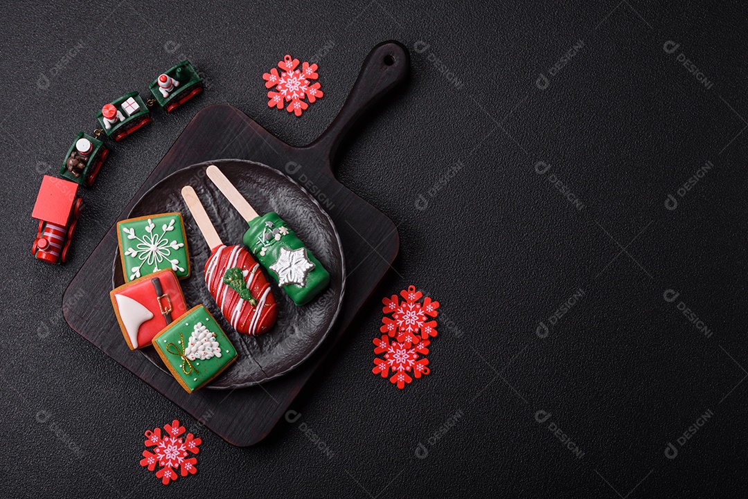 A imagem mostra biscoitos decorados com temática natalina, incluindo um biscoito em forma de picolé e outros em formato quadrado
