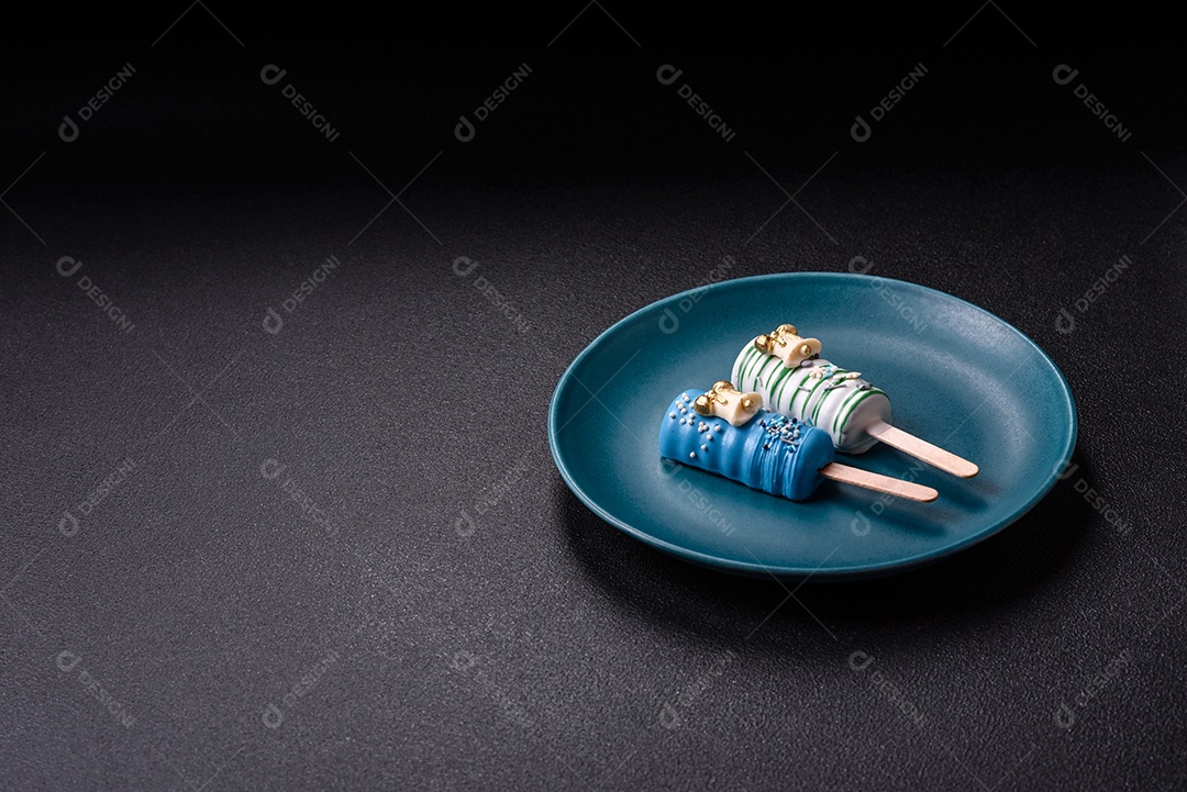 A imagem mostra picolés e biscoitos decorados, que são tipos de doces ou sobremesas