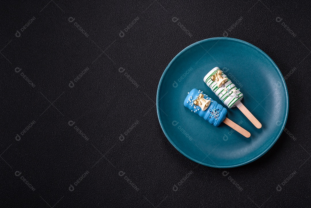 A imagem mostra picolés e biscoitos decorados, que são tipos de doces ou sobremesas