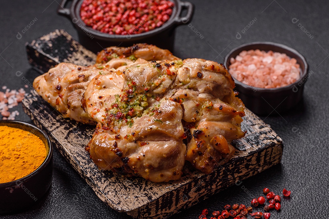 A imagem mostra sobrecoxas de frango grelhadas, servidas em um prato escuro com temperos