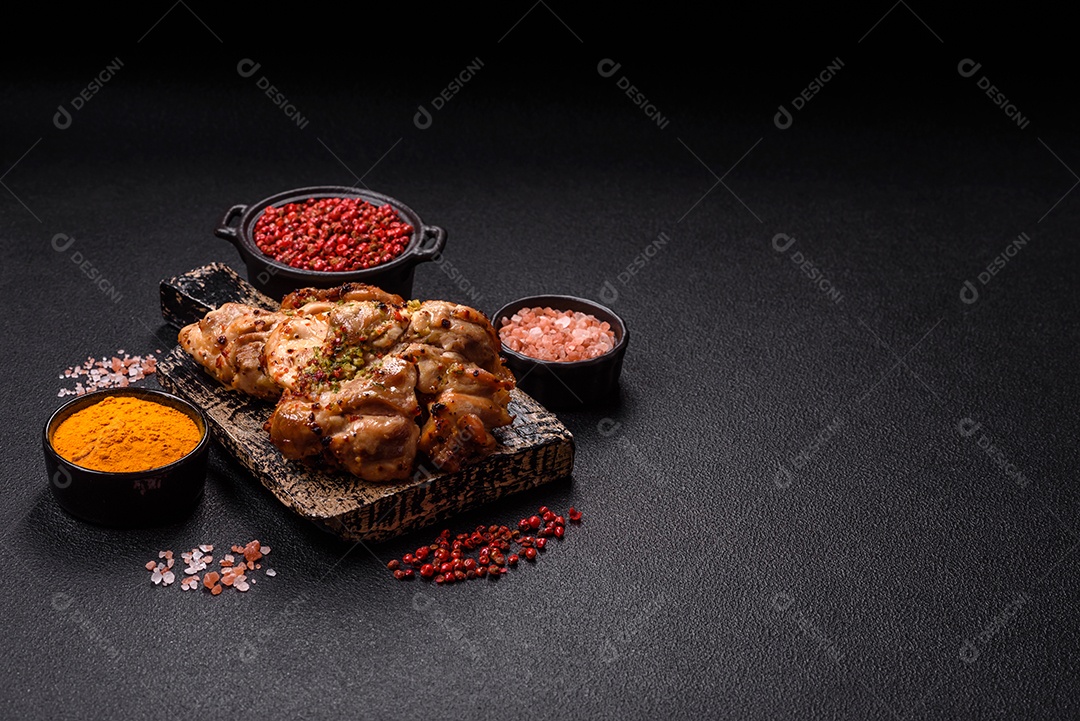 A imagem mostra sobrecoxas de frango grelhadas, servidas em um prato escuro com temperos