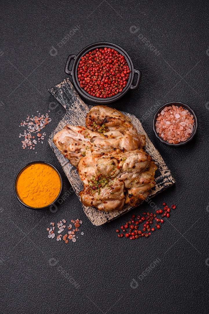 A imagem mostra sobrecoxas de frango grelhadas, servidas em um prato escuro com temperos