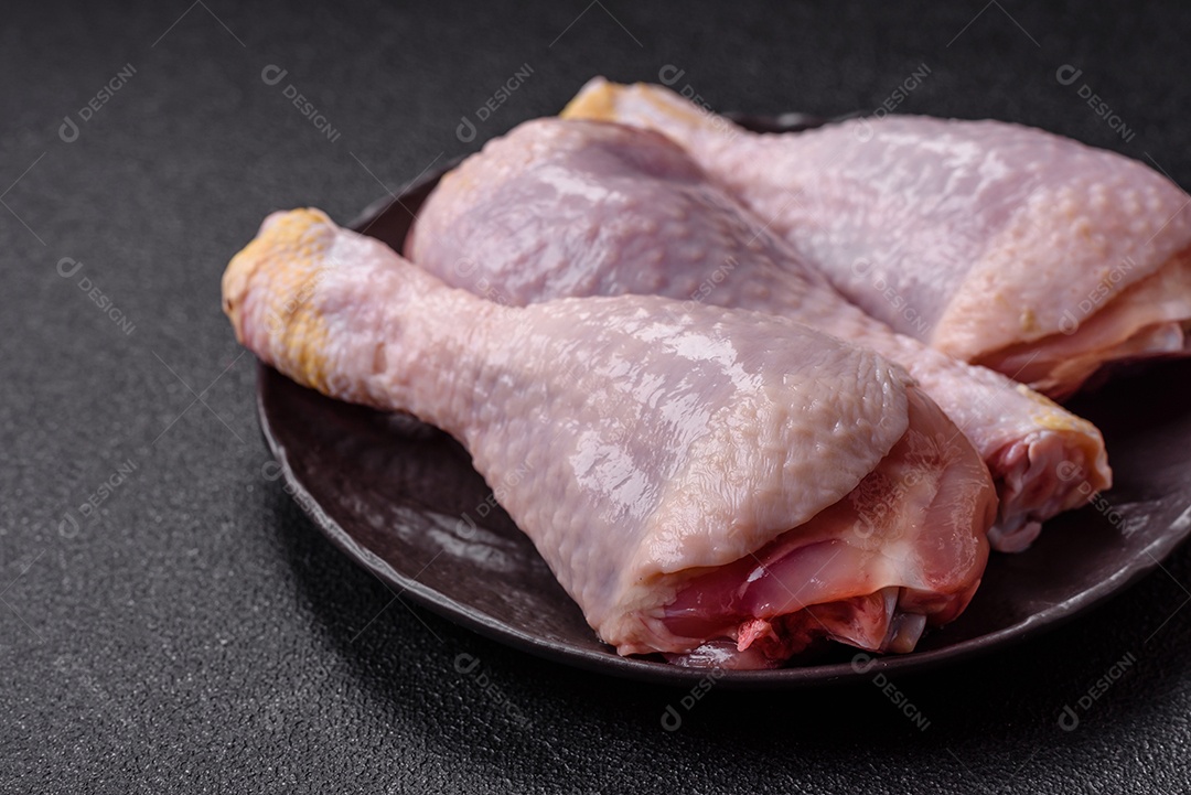 A imagem mostra sobrecoxas de frango cruas em um prato.