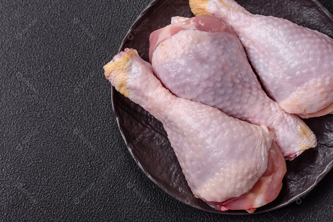 A imagem mostra sobrecoxas de frango cruas em um prato.