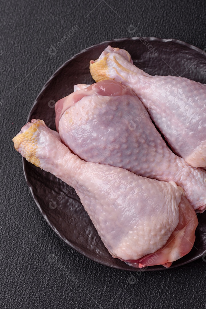 A imagem mostra sobrecoxas de frango cruas em um prato.