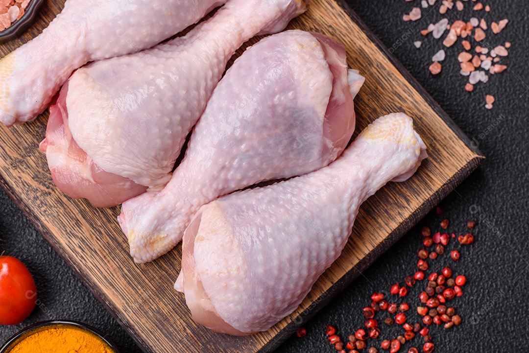 A imagem mostra sobrecoxas de frango cruas em um prato.